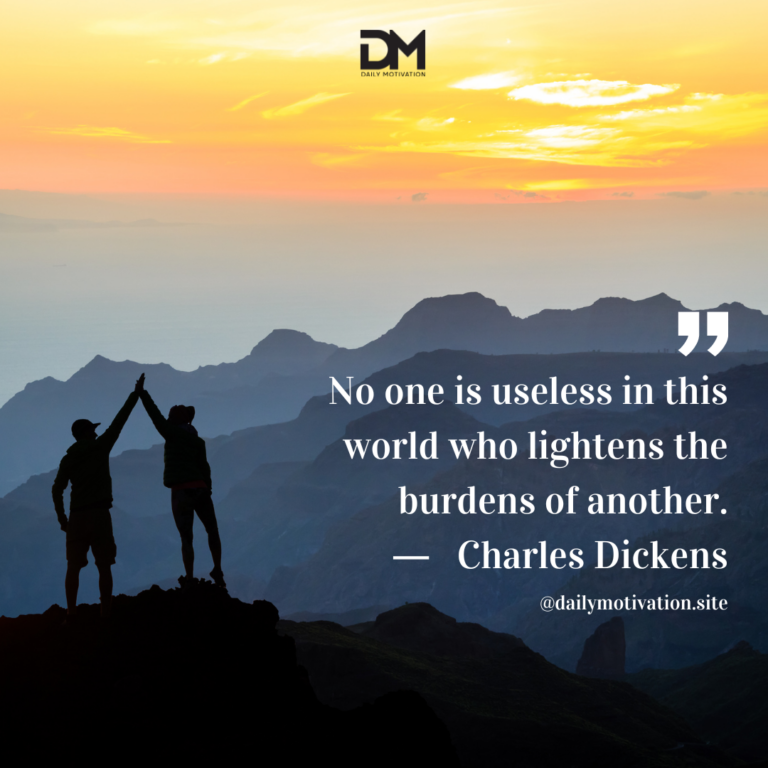 Two people in silhouette high five on top of a cliff with the sunset beyond them.