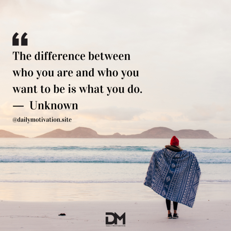 A woman walks on the beach at sunset, wrapped in a blanket.