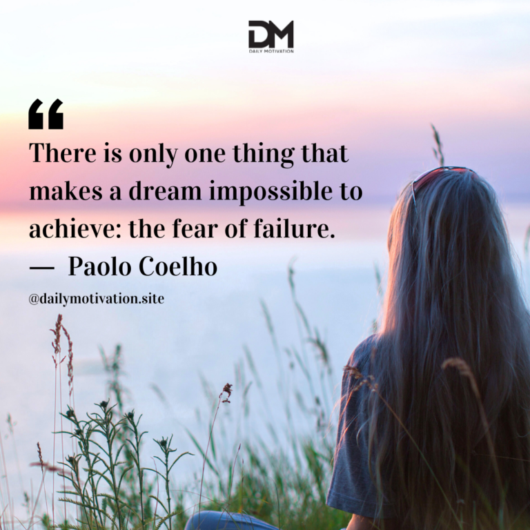 A woman sits in some grass, looking out at the water and a light pink sky.