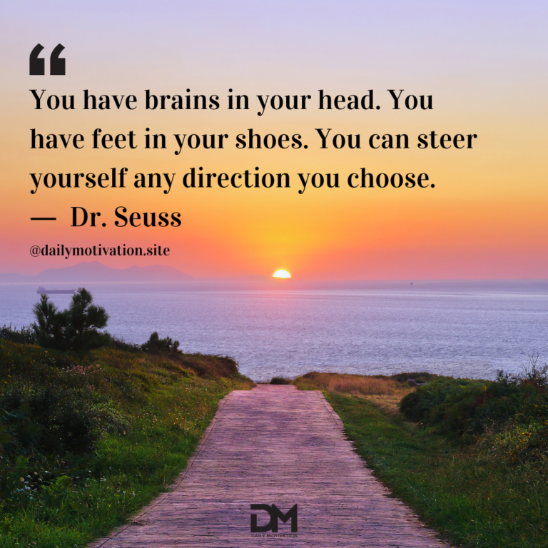 A path leading to the ocean with a purple and orange sunset beyond.