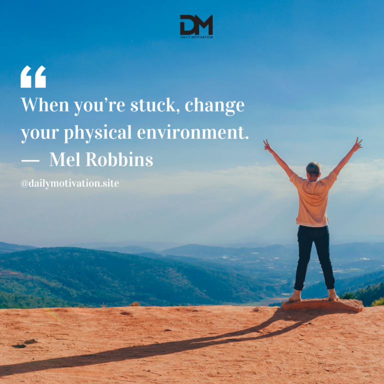 A person in an orange shirt stands on top of a mountain with their arms spread to the sky.