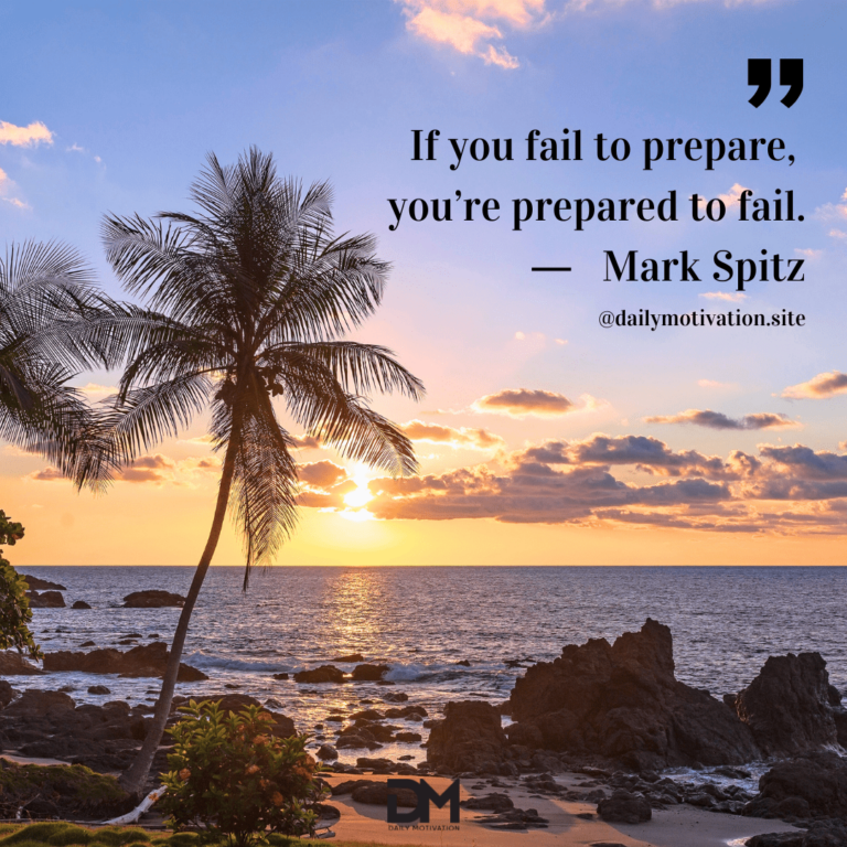 A palm tree stands out on the rocks of the shore of the ocean at sunset.