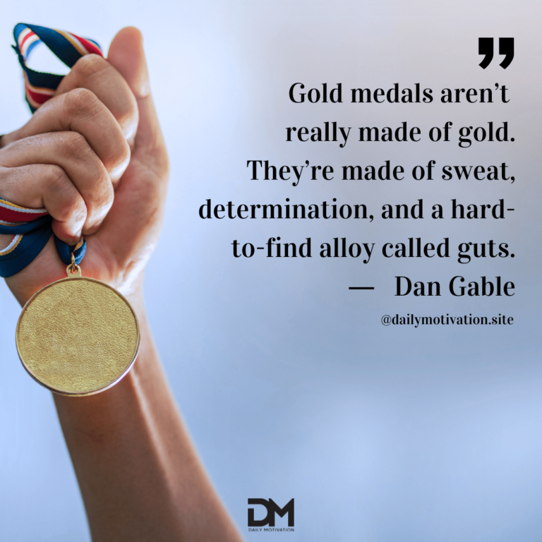 A hand grasps a gold medal in the air. Text reads: Gold medals aren't really made of gold. They're made of sweat, determination, and a hard-to-find alloy called guts. - Dan Gable