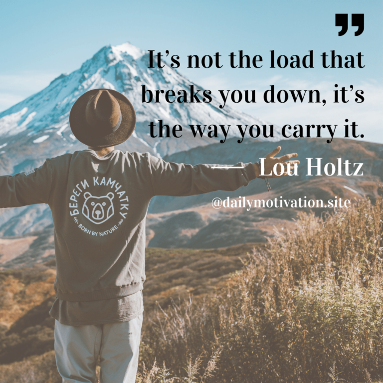 Man spreads his arms wide in front of a mountain.